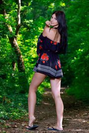 Sexy Russian brunette Aleksandrina walks through the woods in a flirty top and thigh-skimming skirt 00